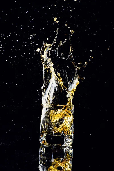 Isolierte Aufnahme von Whisky mit Spritzer auf schwarzem Hintergrund, Brandy — Stockfoto