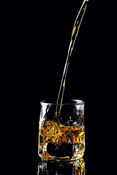 Strzał na białym tle whisky z splash na czarnym tle, brandy — Zdjęcie stockowe