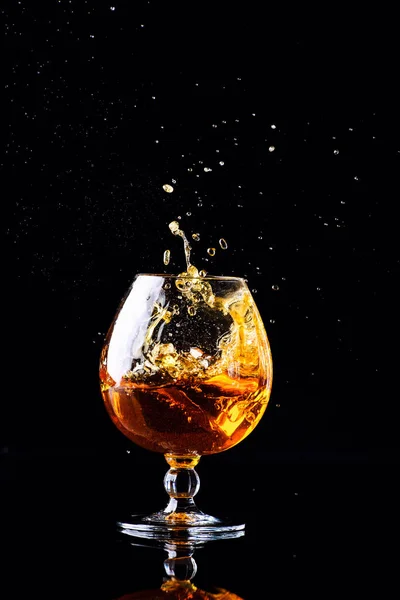 Vetro con cognac su sfondo nero — Foto Stock