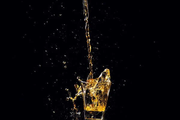 Colpo isolato di whisky con spruzzata su fondo nero, brandy — Foto Stock