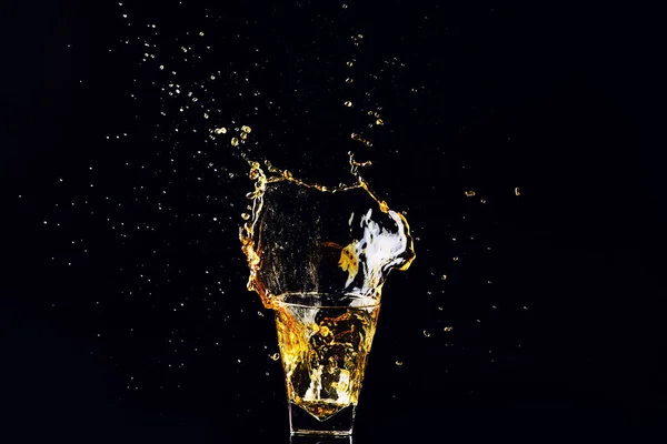 Colpo isolato di whisky con spruzzata su fondo nero, brandy — Foto Stock