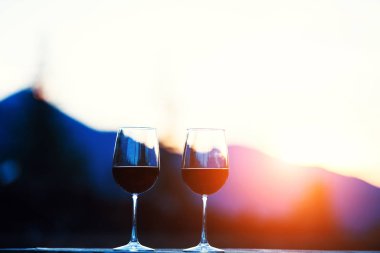 İki bardak şarap günbatımı dramatik gökyüzü üzerinde dağ manzarası