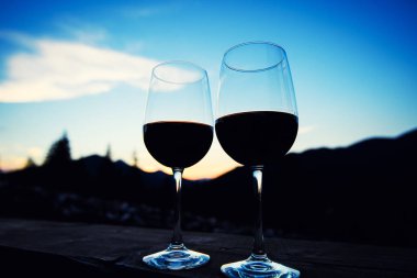İki bardak şarap günbatımı dramatik gökyüzü üzerinde dağ manzarası
