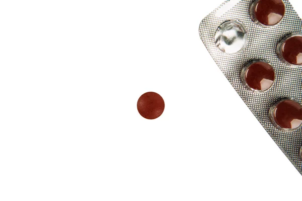 Brązowe tabletki w blistrze na białym tle — Zdjęcie stockowe