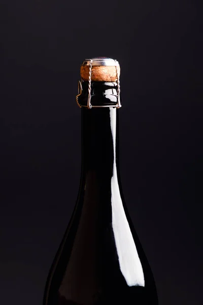 Детали бутылки шампанского с пробкой на черном фоне — стоковое фото