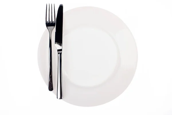 Assiette blanche vide avec le couteau et la fourchette sur fond blanc — Photo