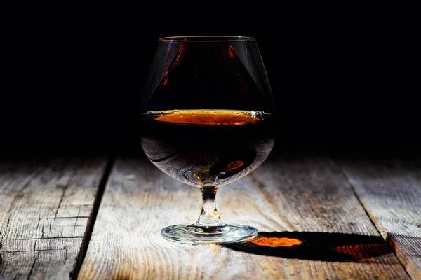 Glas mit Cognac auf Holzgrund — Stockfoto
