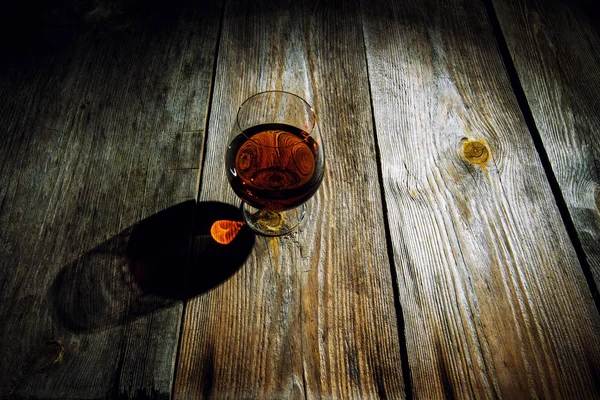 Glas med cognac på en trä bakgrund — Stockfoto