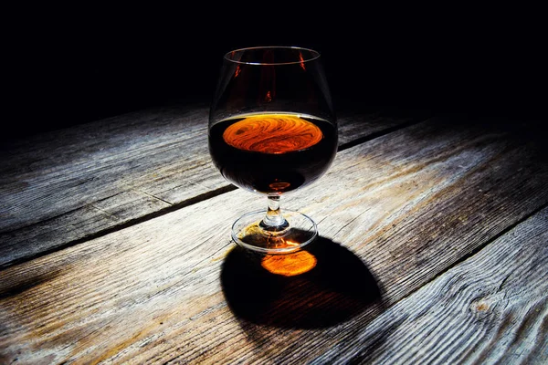 Glass with cognac on a wooden background — Stock Photo, Image