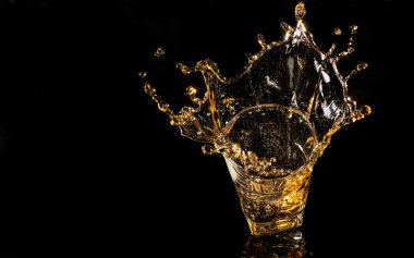 Siyah arka planda buz küpünden sıçramış bir bardak viski. Alkol sıçraması. viski ya da konyak ya da başka bir çeşit alkol..