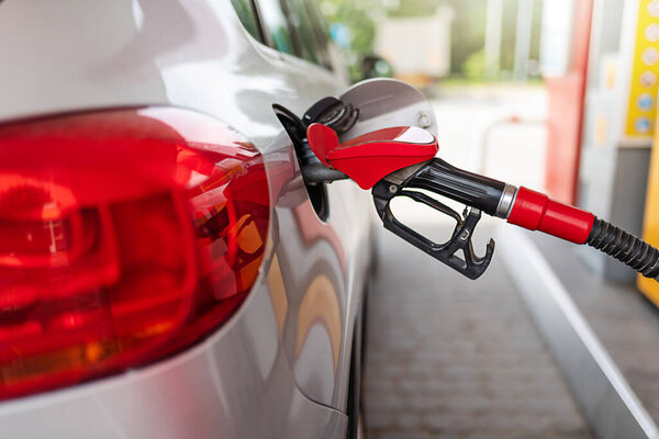 silver car refuelling at the gas station, the concept of fuel energy