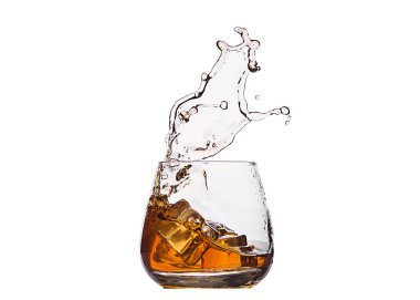 Beyaz üzerine izole edilmiş buz küpünden sıçramış bir bardak viski. Alkol sıçraması. Viski, konyak ya da başka bir tür alkol..