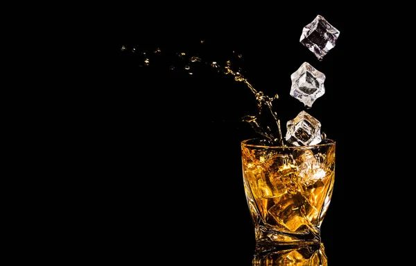 Ein Glas Whisky Mit Spritzern Aus Dem Eiswürfel Vor Schwarzem — Stockfoto
