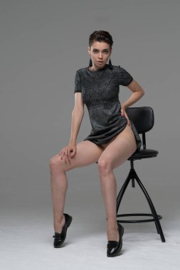 Genç güzel kız elbise stüdyoda oturup Studio'da poz