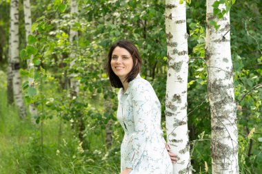 Genç güzel kız yaz huş yakınındaki beyaz elbiseli poz