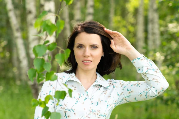 Genç güzel kız yaz huş yakınındaki beyaz elbiseli poz