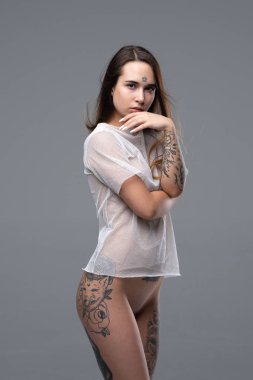 Genç güzel kız beyaz bir bluz daimi stüdyoda çıplak poz