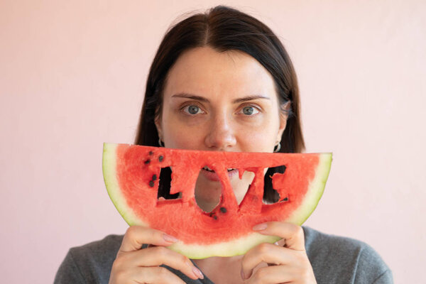 portrait of a young beautiful girl holding a slice of watermelon