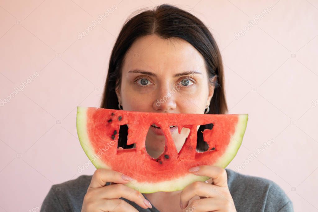 portrait of a young beautiful girl holding a slice of watermelon