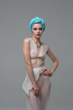 Genç güzel kız stüdyoda ayakta beyaz şeffaf giysiler içinde poz