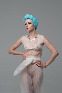 Genç güzel kız stüdyoda ayakta beyaz şeffaf giysiler içinde poz