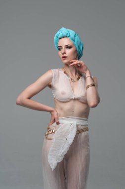 Genç güzel kız stüdyoda ayakta beyaz şeffaf giysiler içinde poz