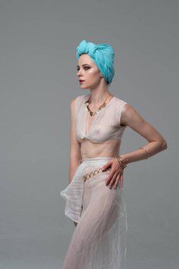 Genç güzel kız stüdyoda ayakta beyaz şeffaf giysiler içinde poz