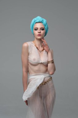 Genç güzel kız stüdyoda ayakta beyaz şeffaf giysiler içinde poz