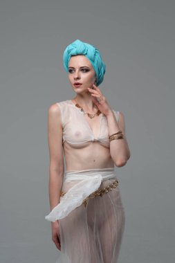 Genç güzel kız stüdyoda ayakta beyaz şeffaf giysiler içinde poz