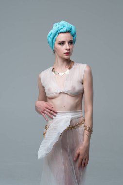 Genç güzel kız beyaz şeffaf iç çamaşırlarıyla ayakta stüdyoda poz