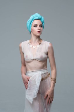 Genç güzel kız beyaz şeffaf iç çamaşırlarıyla ayakta stüdyoda poz