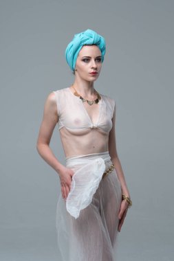 Genç güzel kız beyaz şeffaf iç çamaşırlarıyla ayakta stüdyoda poz