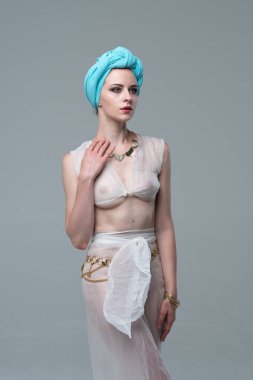 Genç güzel kız beyaz şeffaf iç çamaşırlarıyla ayakta stüdyoda poz