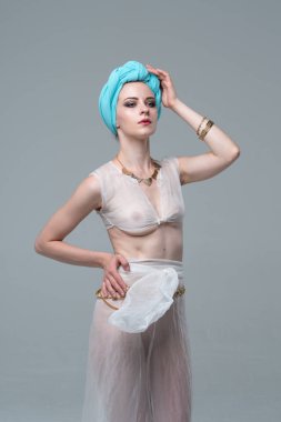 Genç güzel kız beyaz şeffaf iç çamaşırlarıyla ayakta stüdyoda poz