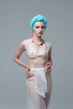 Genç güzel kız stüdyoda ayakta beyaz şeffaf giysiler içinde poz