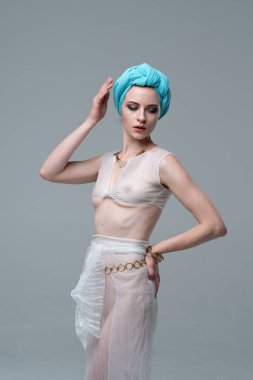 Genç güzel kız stüdyoda ayakta beyaz şeffaf giysiler içinde poz