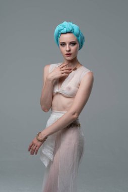 Genç güzel kız beyaz şeffaf iç çamaşırlarıyla ayakta stüdyoda poz