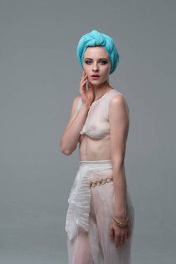 Genç güzel kız beyaz şeffaf iç çamaşırlarıyla ayakta stüdyoda poz