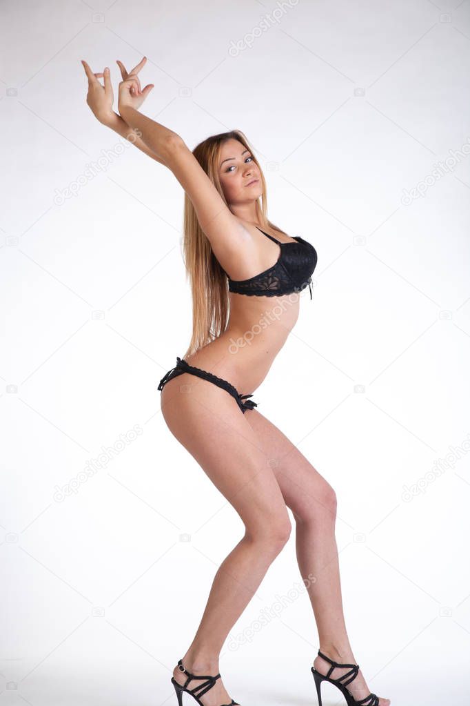 young beautiful girl posing in the studio, standing in black lingerie