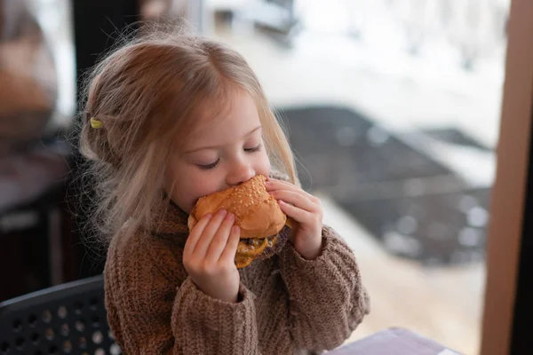 küçük kız kafede hamburger yemek