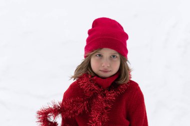 Kışın dışında küçük bir kızın portre, kırmızı bir şapka ayakta