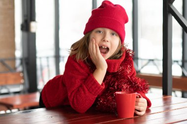 Noel'de bir kafede oturan küçük kız