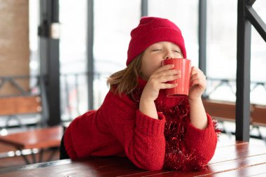 Noel'de bir kafede oturan küçük kız