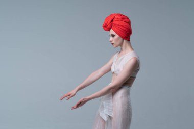 Genç güzel kız stüdyoda ayakta beyaz şeffaf giysiler içinde poz