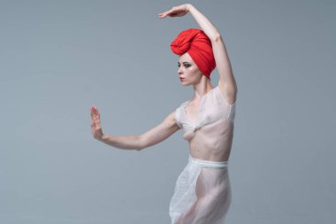 Genç güzel kız stüdyoda ayakta beyaz şeffaf giysiler içinde poz