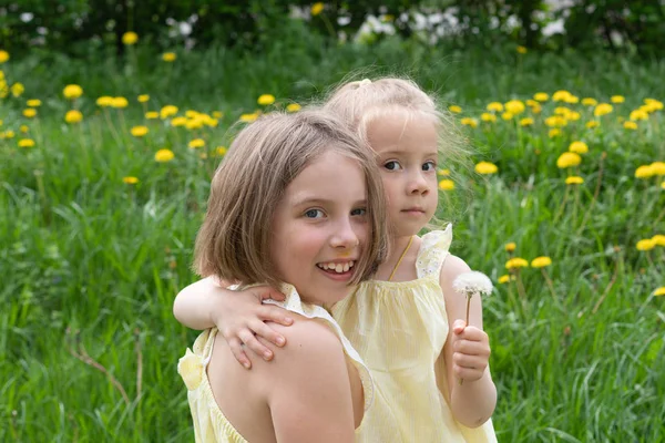 Two Girls Standing Green Grass Yellow Dresses Dandelions — Stock Photo, Image