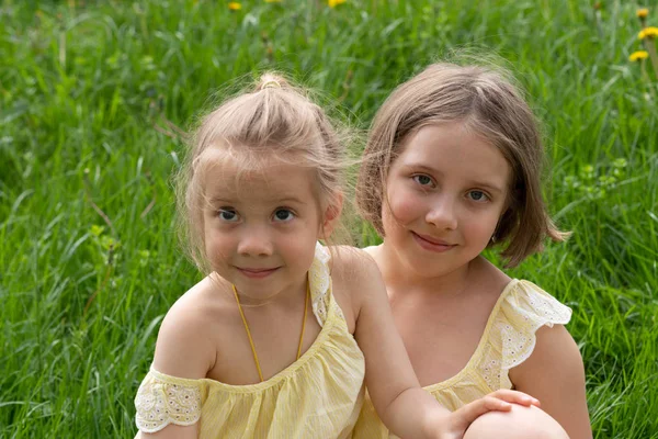 Two Girls Standing Green Grass Yellow Dresses Dandelions — Stock Photo, Image