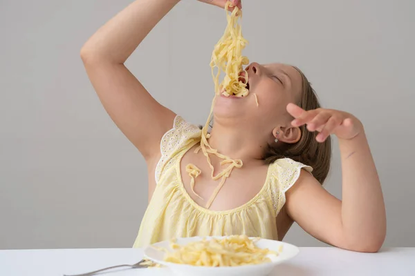 Menina Comendo Macarrão Sentado Uma Mesa Vestido Amarelo — Fotografia de Stock