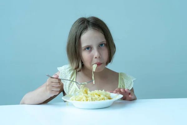 Menina Comendo Macarrão Sentado Uma Mesa Vestido Amarelo — Fotografia de Stock