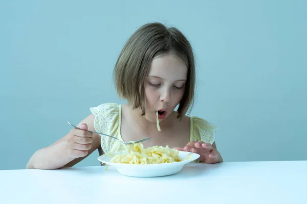 Menina Comendo Macarrão Sentado Uma Mesa Vestido Amarelo — Fotografia de Stock